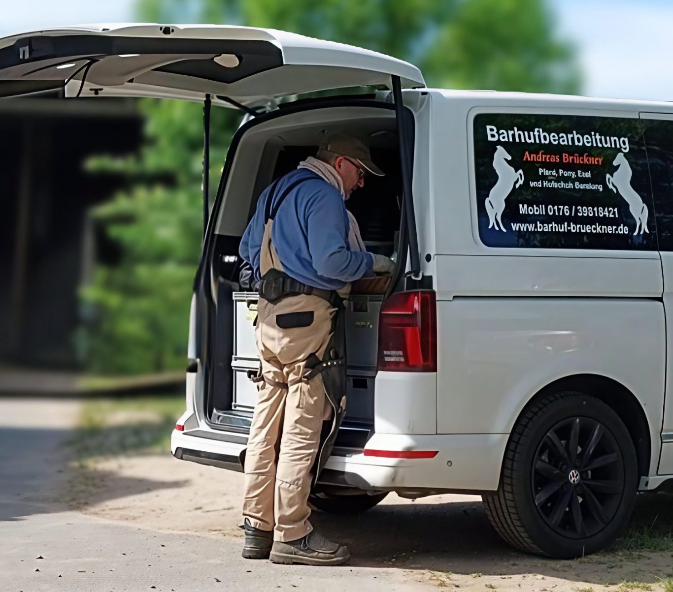 Andreas Brückner in Arbeitskleidung steht an seinem weißen Transporter.